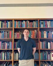 Anthony Veneziani standing in front of bookcase