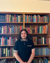 Cody Pender Cody Pender in front of bookcase