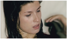 The image is the still from the film View from the Eiffel Tower. This image includes a close up image of a woman with wet hair.