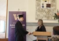 Anthony Veneziani in a cap and gown receiving his diploma.