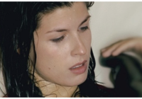The image is the still from the film View from the Eiffel Tower. This image includes a close up image of a woman with wet hair.